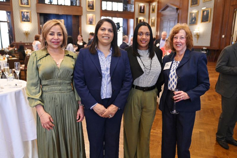 Four Pan American Day 2024 female attendees in business attire posing together at conference